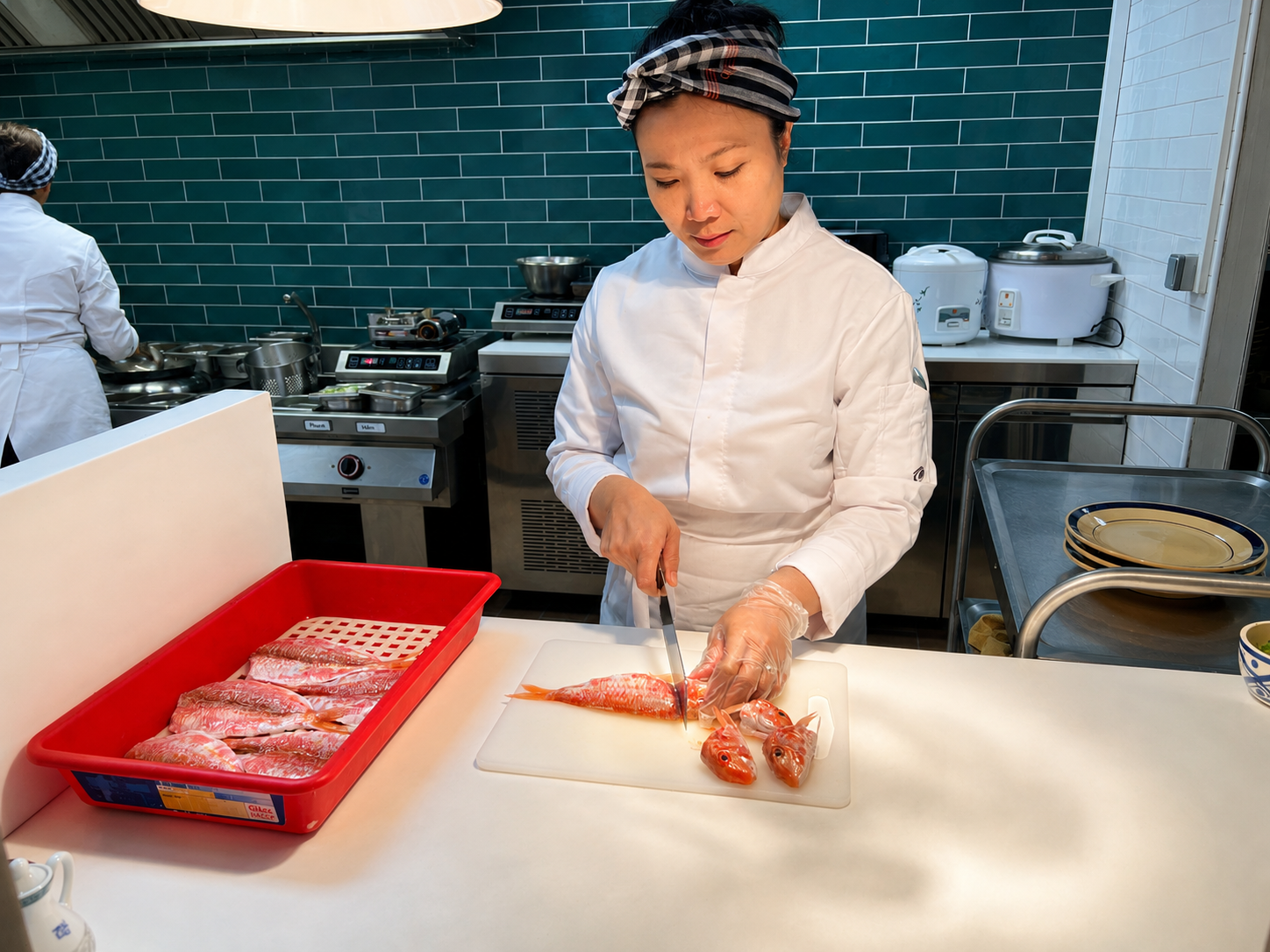 La Cheffe Kim Huệ préparant un plat signature dans sa cuisine gastronomique